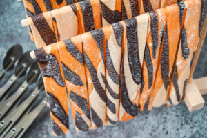 Tiger Pappardelle hanging from a wooden stand.