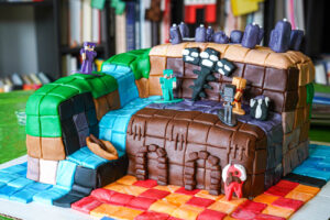 Side view of Minecraft Adventure Cake with a book case in the background.