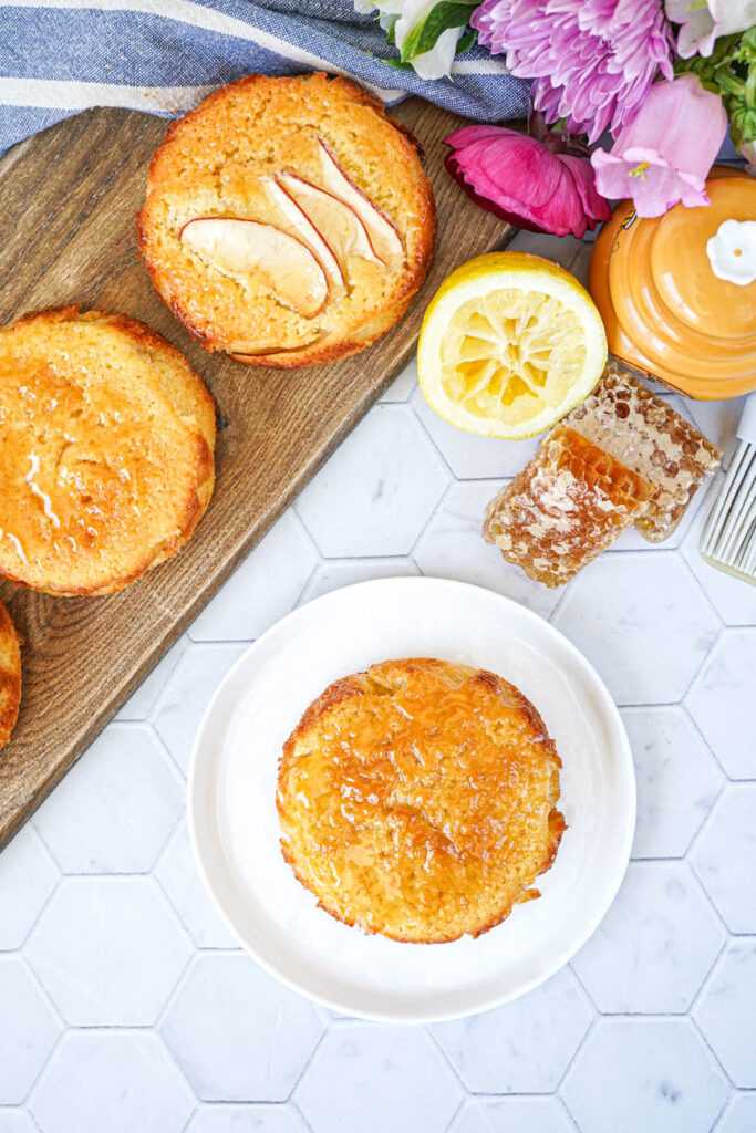 Aerial view of The Best Basic Butter Cake on a plate and board next to honeycomb and lemon.