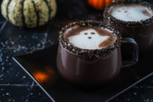 Dark Hot Cocoa in two clear mugs with ghost latte art.