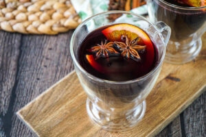 Mulled wine in two glasses with orange slices and star anise.