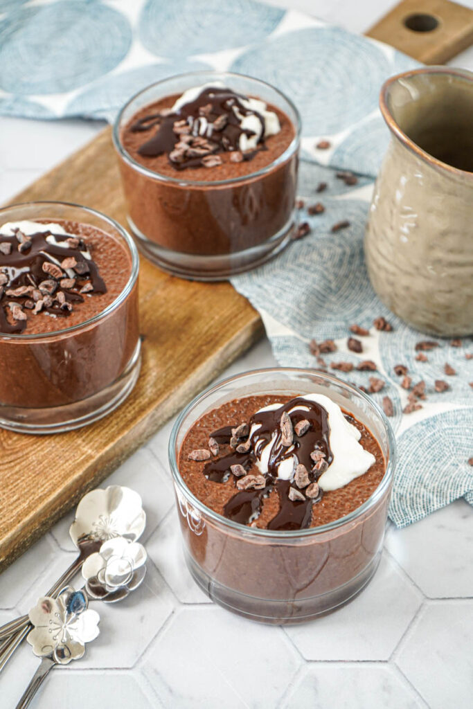 Espresso Chia Pudding with Espresso Cacao Sauce in three glasses next to three flower spoons.