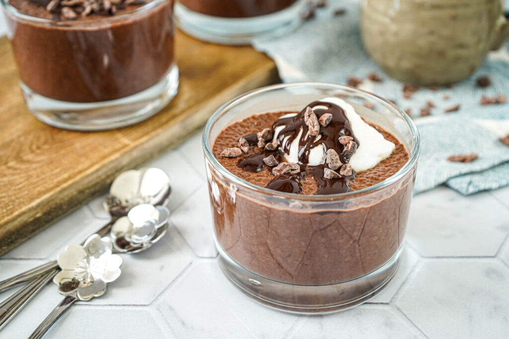 Espresso Chia Pudding with Espresso Cacao Sauce in three glasses with coconut yogurt and cacao nibs.