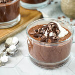 Espresso Chia Pudding with Espresso Cacao Sauce in three glasses with cacao nibs.