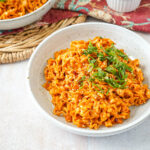Spicy Peanut Noodles in a bowl with green onions.
