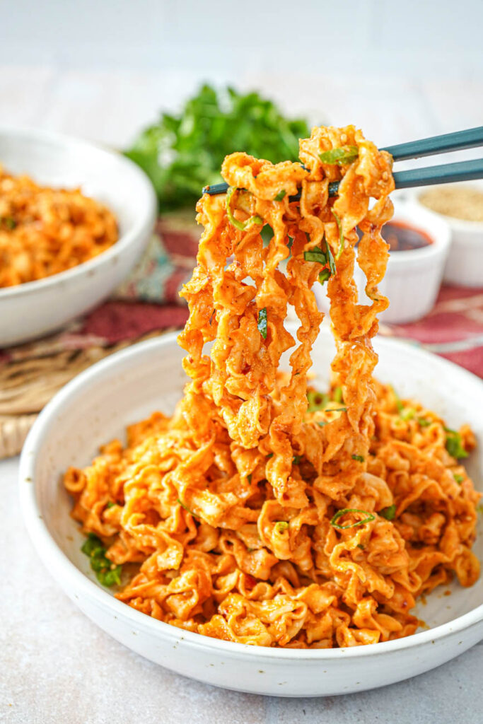 Holding up Spicy Peanut Noodles with a pair of chopsticks.