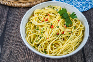 Spaghetti Ajo, Ojo e Peperoncino in a bowl with parsley sprigs.