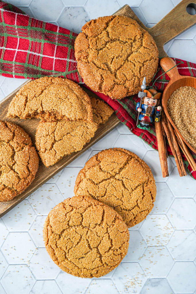 Aerial view of Giant Gingersnap Cookies next to cinnamon sticks, turbinado sugar, and a nutcracker ornament.