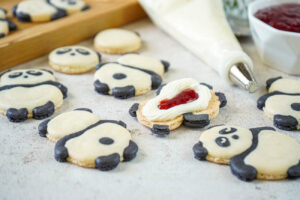 White Chocolate Ganache with Raspberry Jam piped over a panda bear macaron.