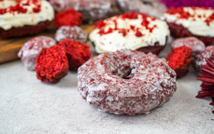Red Velvet Donuts covered in a thin glaze and topped with a cream cheese frosting.