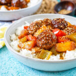Sweet and Sour Pineapple Meatballs over a bed of rice in a bowl.