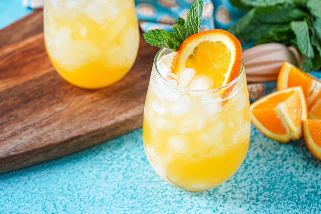 Creamsicle Crush in two glasses with an orange slice and mint sprig for garnish.