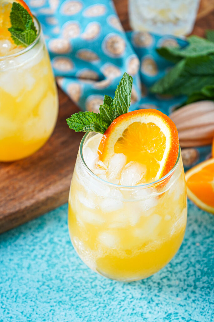 Close up of Creamsicle Crush in a glass with an orange slice and mint sprig.