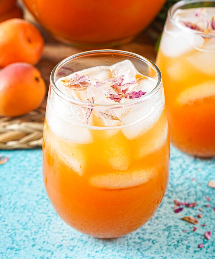 Rose, Apricot and Honey Iced Tea in two glasses next to dried rose petals.