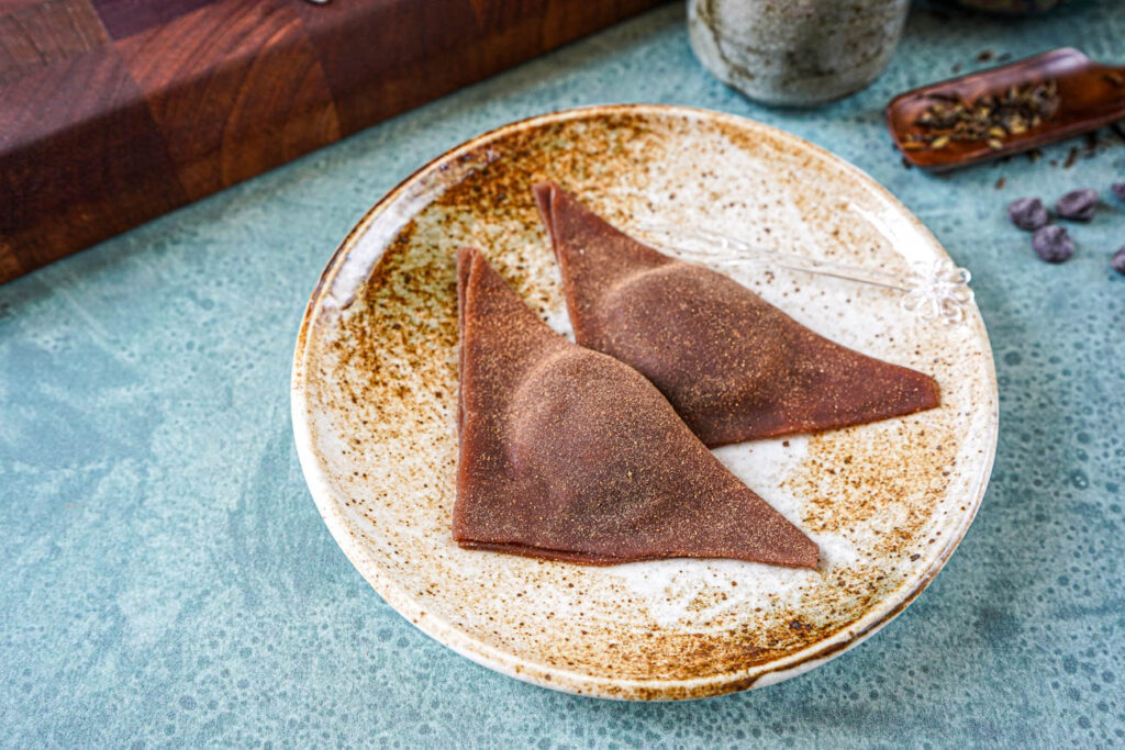 Two Chocolate Nama Yatsuhashi on a brown plate.