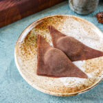 Two Chocolate Nama Yatsuhashi on a brown plate.