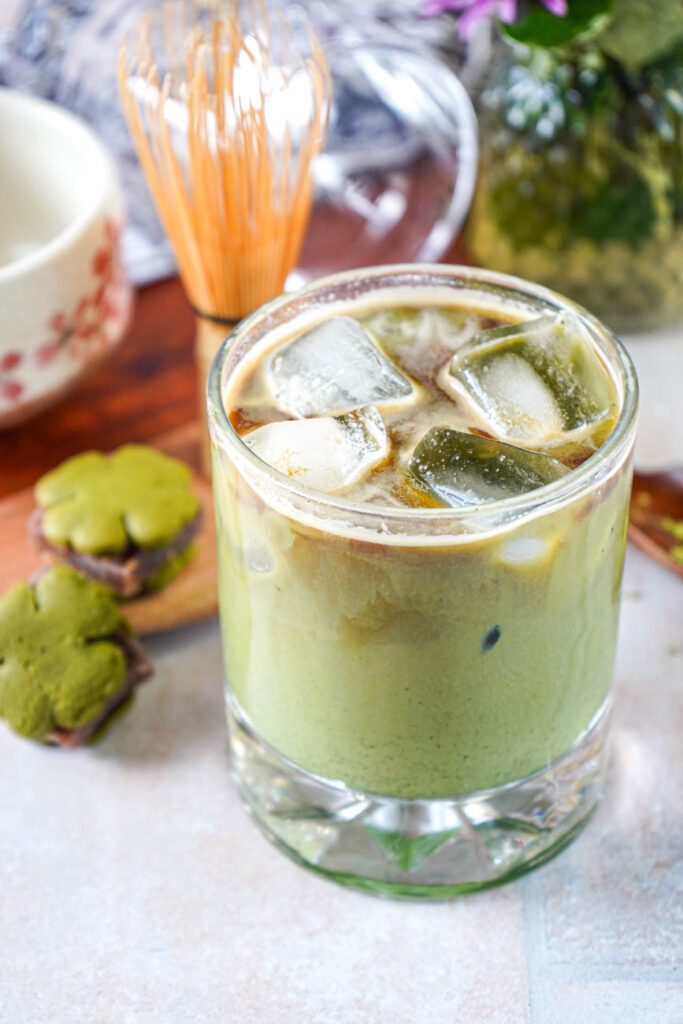 Iced Matcha Espresso Latte blended together next to two matcha cookies.