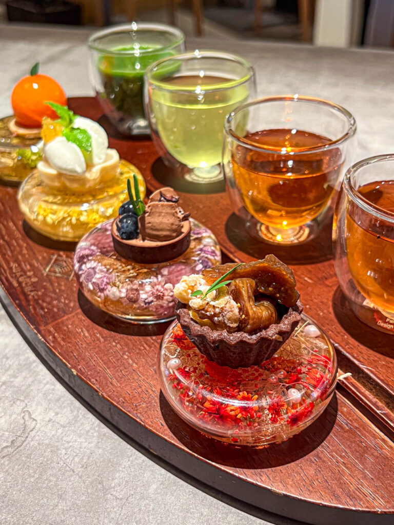 Tea and dessert flight from Saryo Fukucha with four cups of tea and four small pastries.