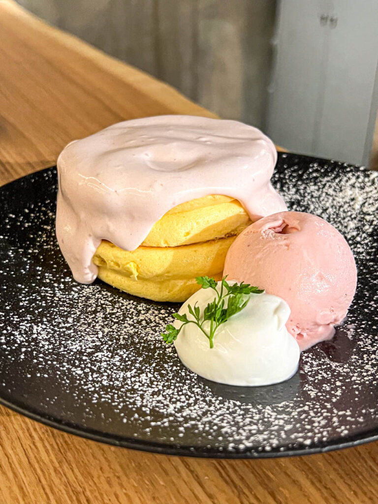 A stack of strawberry pancakes with whipped cream and ice cream from Pancake Room.