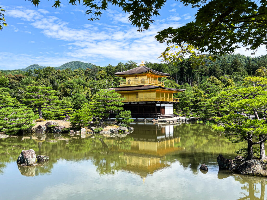 Kinkaku-ji on a pond surrounded by trees.