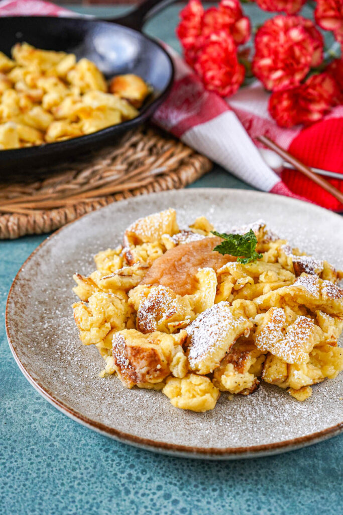 Close up of Cholermüs on a plate with a cast iron pan and flowers in the background.