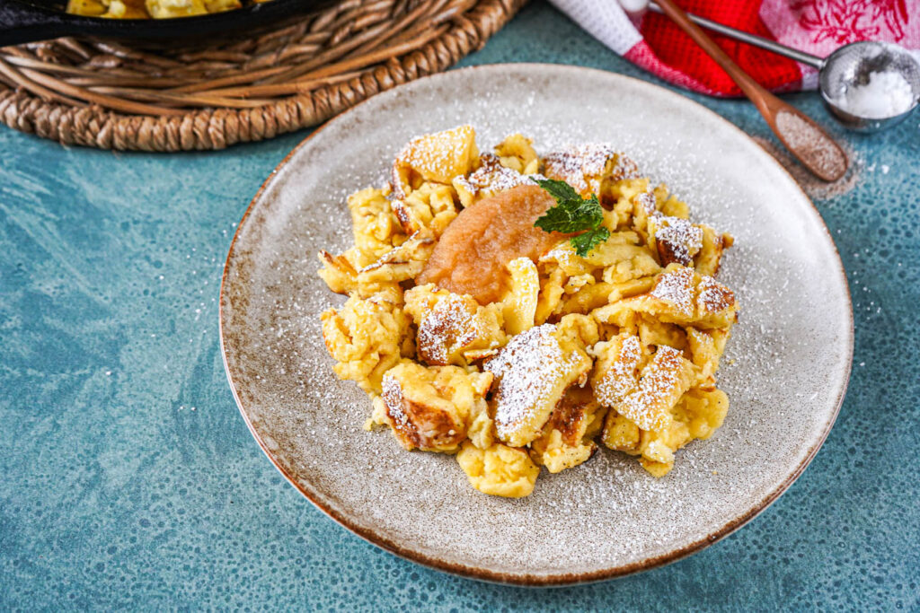 Cholermüs on a plate with applesauce, powdered sugar, and a mint sprig.