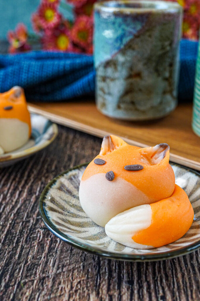 Close up of Fox Nerikiri with a teacup in the background.