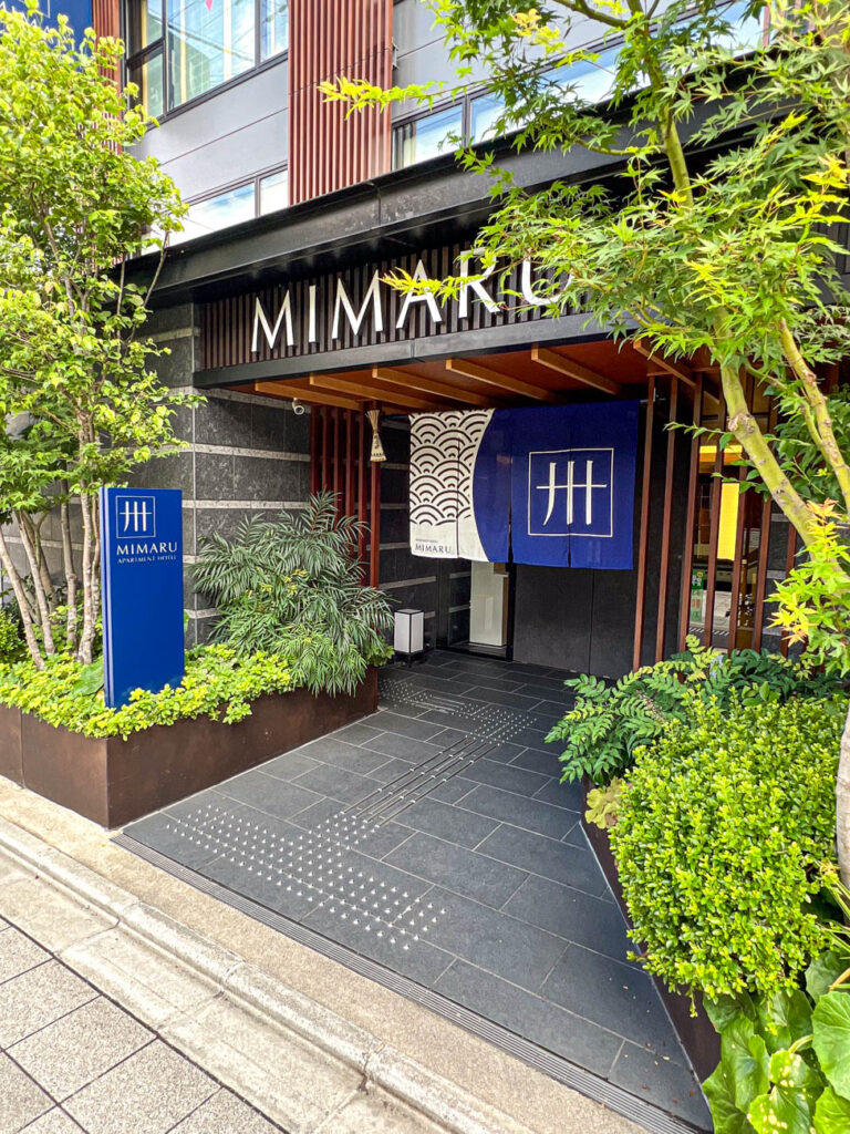 Entrance to Mimaru Kyoto Station surrounded by greenery.