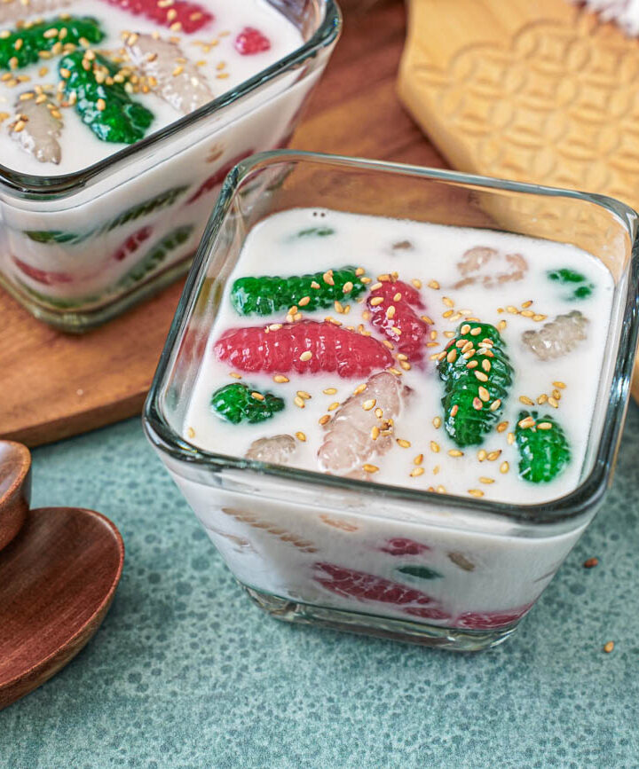 Krong Krang Nam Kati in two glass bowls next to two wooden spoons.