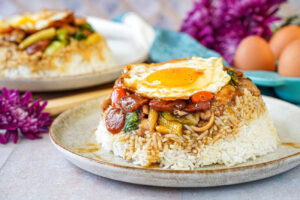 Mauritian Bol Renversé (Upside-Down Bowl) with rice, vegetables, chicken, sausage, and an egg on top.