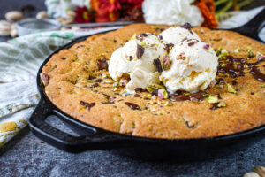 Pistachio Skillet Cookie topped with three scoops of vanilla ice cream.