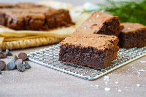 Three slices of Brown Sugar Brown Butter Brownies on a wire rack.