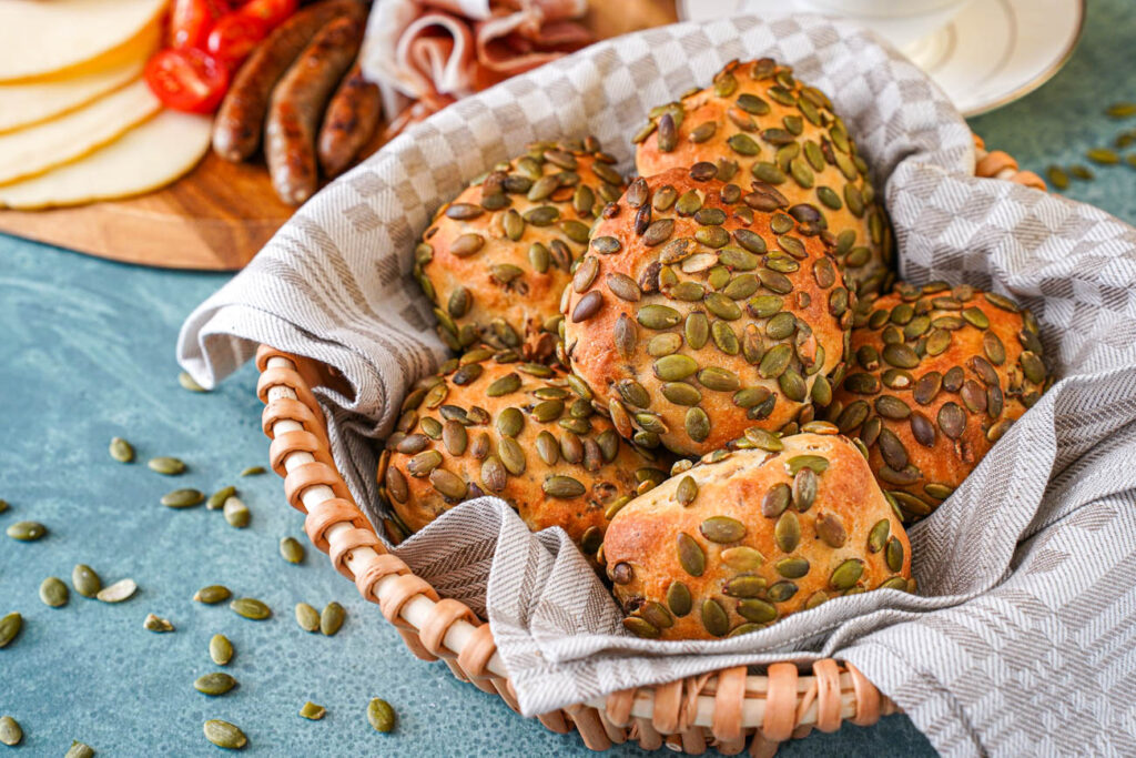 Kürbiskernbrötchen (Pumpkin Seed Rolls) in a basket with a towel.