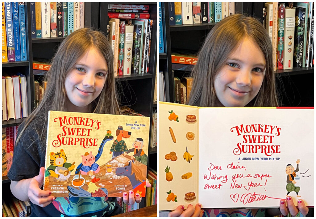 Girl holding Monkey's Sweet Surprise book and opening the cover to show signature by Patricia.