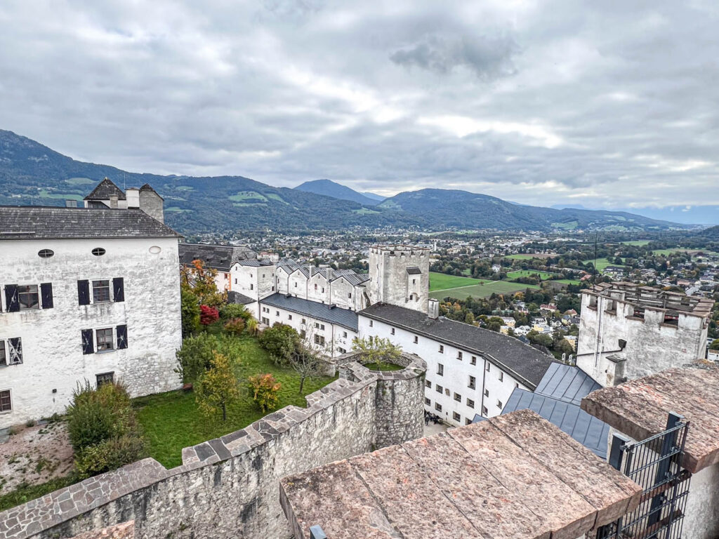 Outside walls of Festung Hohensalzburg with mountains in the distance.