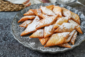 A pile of Sakar Para on a gray plate and covered with powdered sugar.