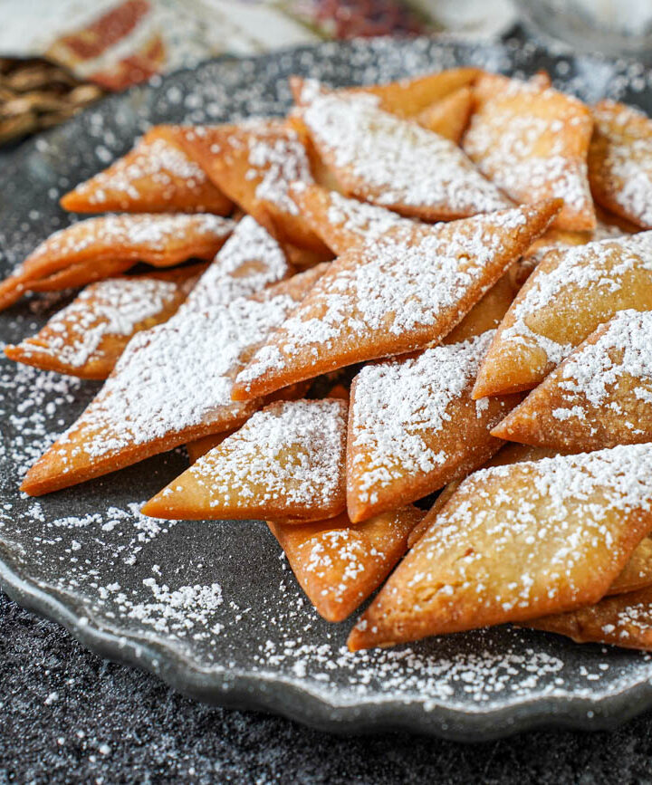 A pile of Sakar Para on a gray plate and covered with powdered sugar.