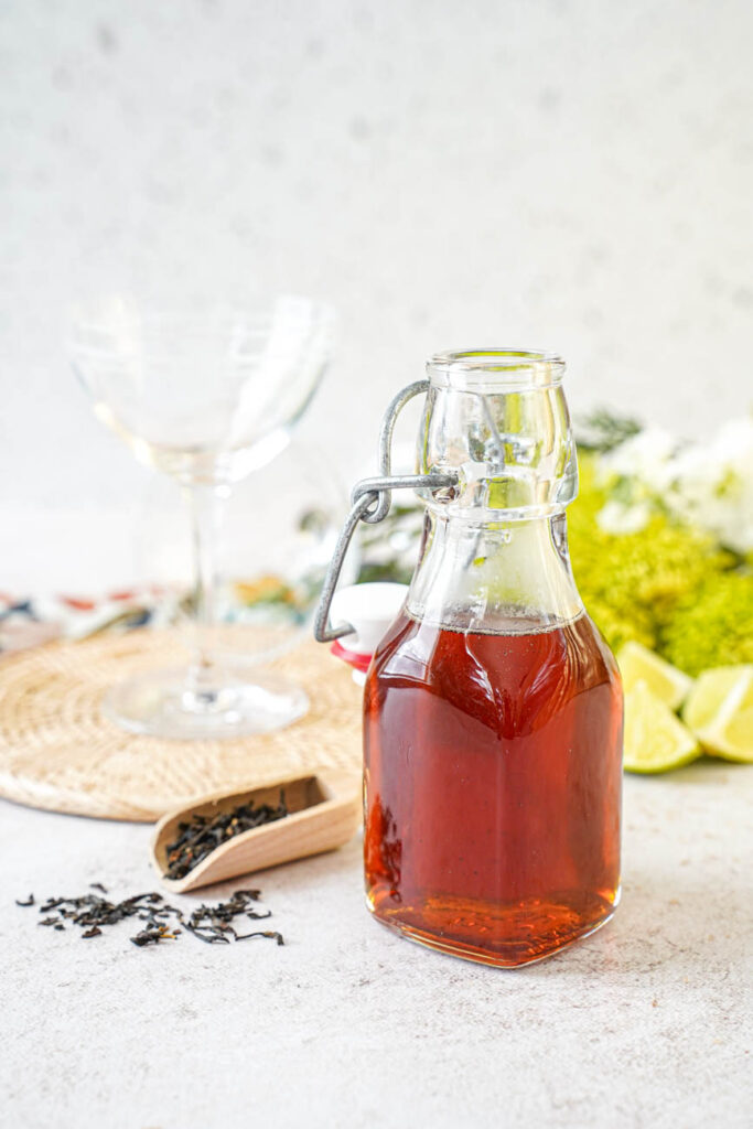 Jar of Lapsang Syrup next to a scoop of tea leaves.