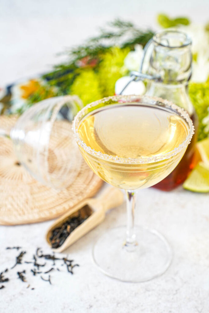 Close up of Smoky Lapsang Martini in a glass next to a scoop of tea leaves.