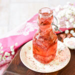 Cherry Blossom Syrup in a glass jar next to pink and white cherry blossom chopstick rests.