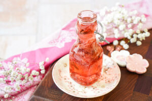 Cherry Blossom Syrup in a glass jar next to pink and white cherry blossom chopstick rests.