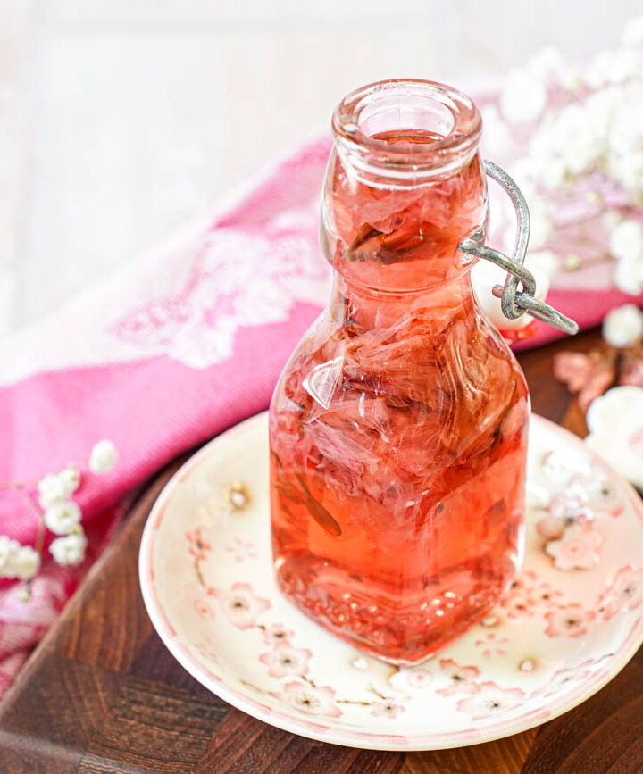 Cherry Blossom Syrup in a glass jar next to pink and white cherry blossom chopstick rests.