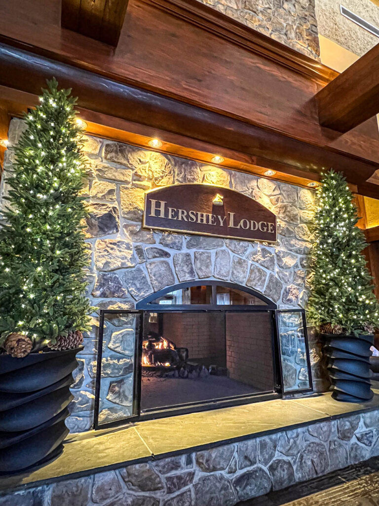 Fire place at Hershey Lodge with two small trees with white lights.