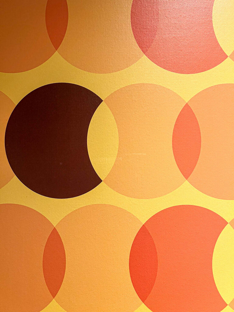 Reese's Peanut Butter Cup design on a wall with orange overlapping circles and one brown peanut butter cup.