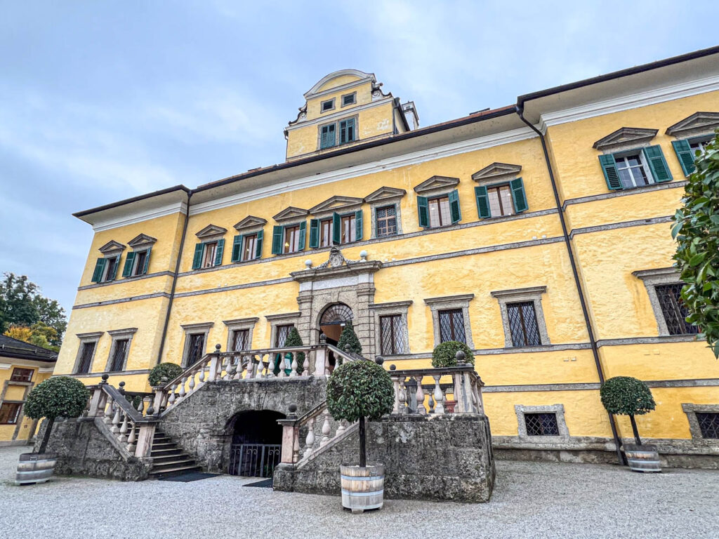 Yellow building with stone steps at Schloss Hellbrunn.