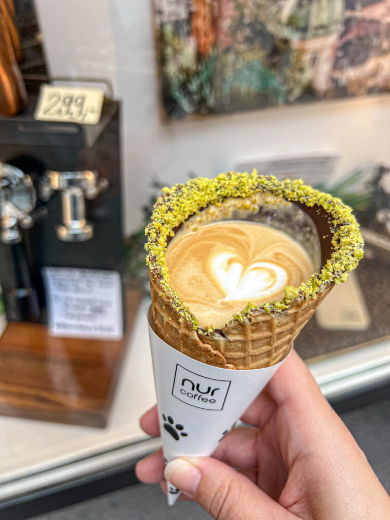Holding a Waffolino con Pistacchio with a small heart latte art on top.