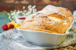 Salzburger Nockerl in a white baking dish with a dusting of powdered sugar.
