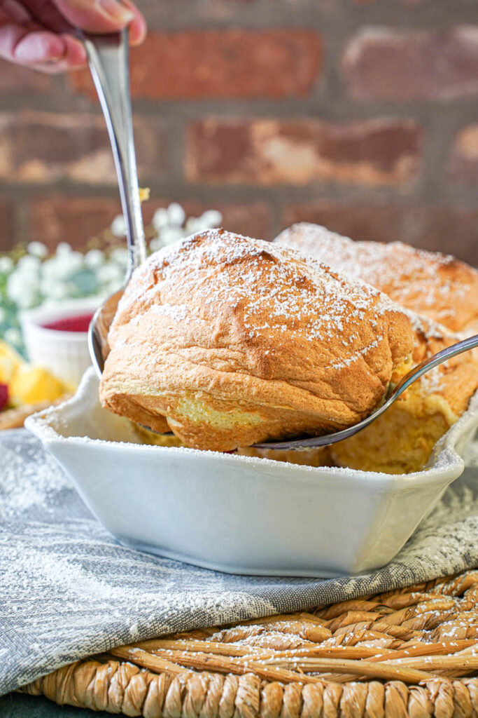 Pulling up a piece of Salzburger Nockerl with two metal spoons.