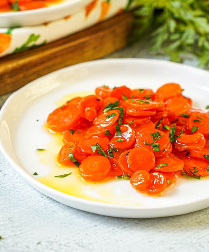 Vichy Carrots (Carottes Vichy) on a white plate with chopped parsley.