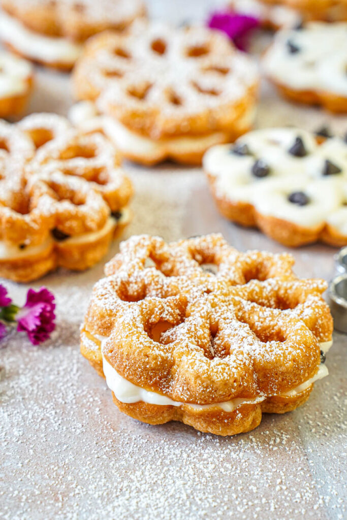 Close up of Baci Panteschi (Flower-Shaped Ricotta-Filled Pastries) dusted with powdered sugar.